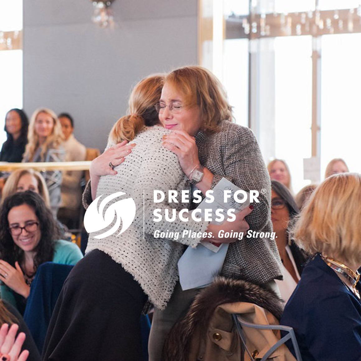 Photo of two women hugging overlaid with  theDress for Success logo and motto: Going places, going strong